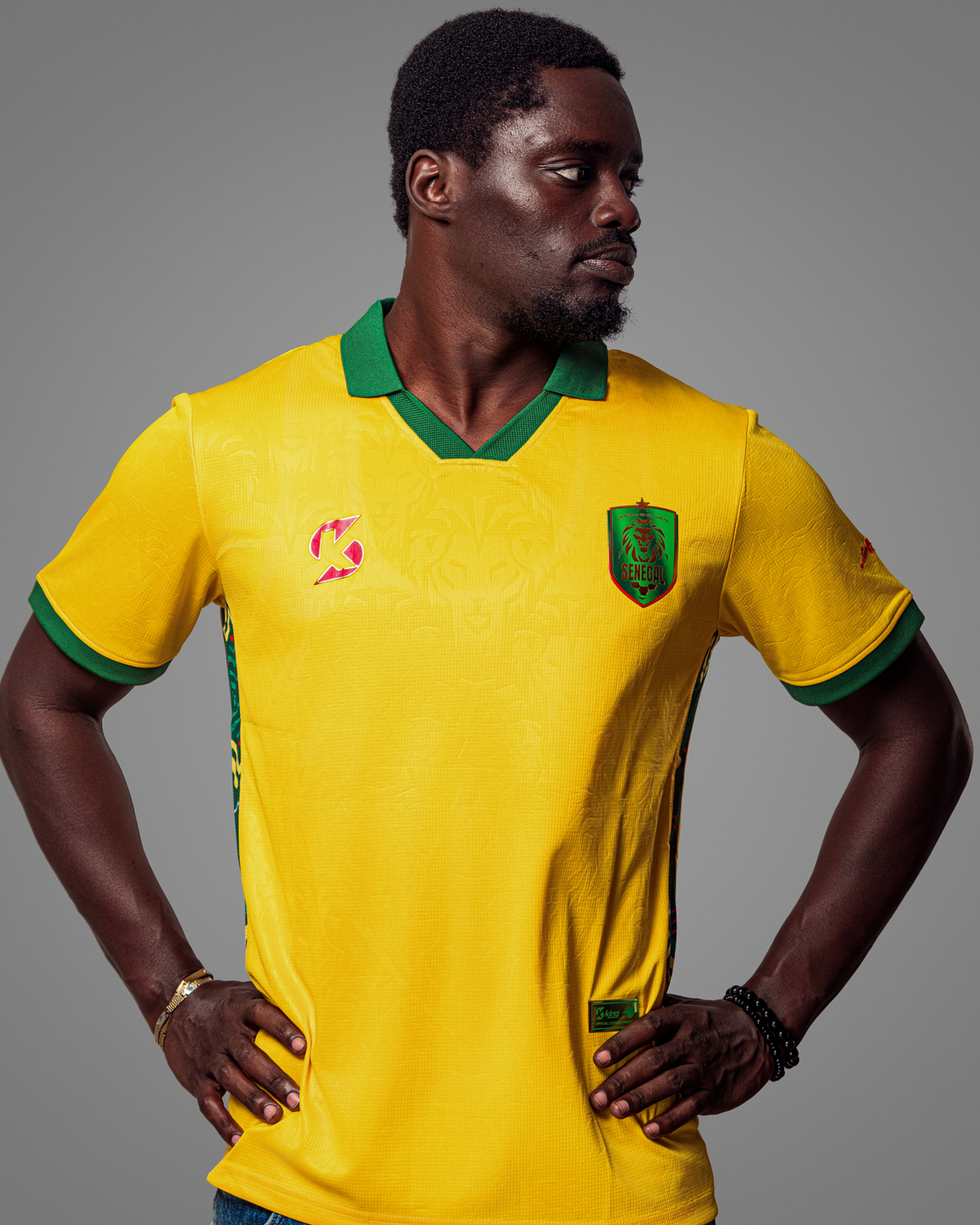 02 Maillot de football jaune vif du Sénégal, col polo vert, avec logo et motifs latéraux.